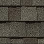 Close-up of a gray brick wall with a textured surface, showcasing several neat rows of evenly spaced bricks.