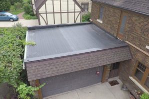 A garage with a flat roof and a brick wall.