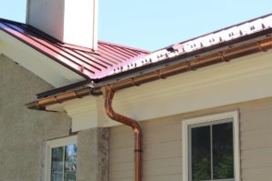 A copper pipe is connected to the roof of a house.